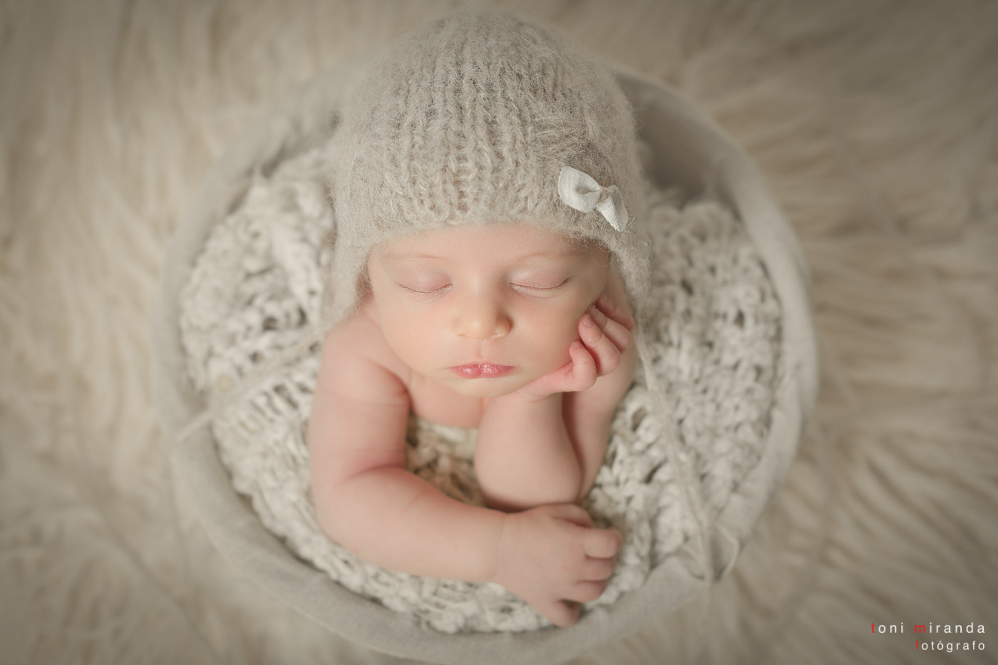 sesión de new born durmiendo dentro de una cesta con gorro de lana en estudio de alcoy de alicante